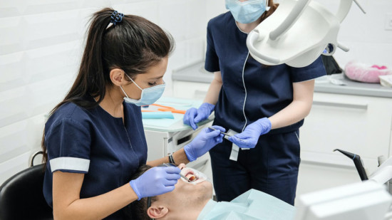 Zahnärztin und Helferin bei der Behandlung